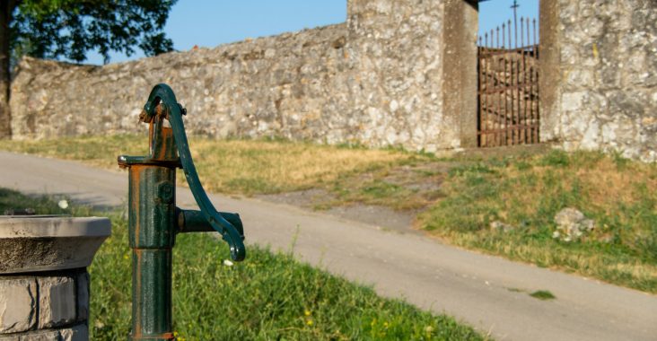 a green fire hydrant sitting on the side of a road