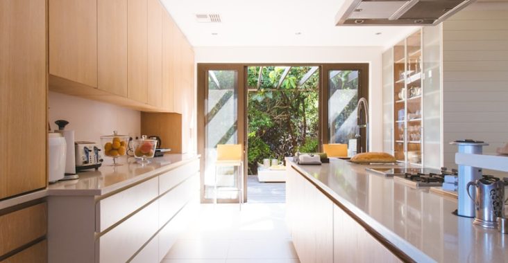 white wooden kitchen island and cupboard cabinets near glass panel door