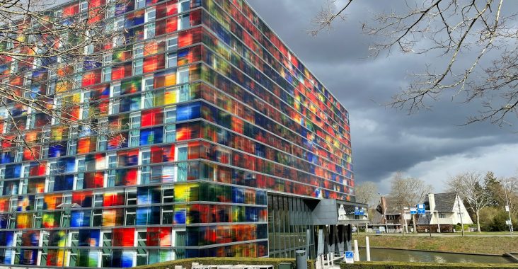 a multicolored building with benches in front of it