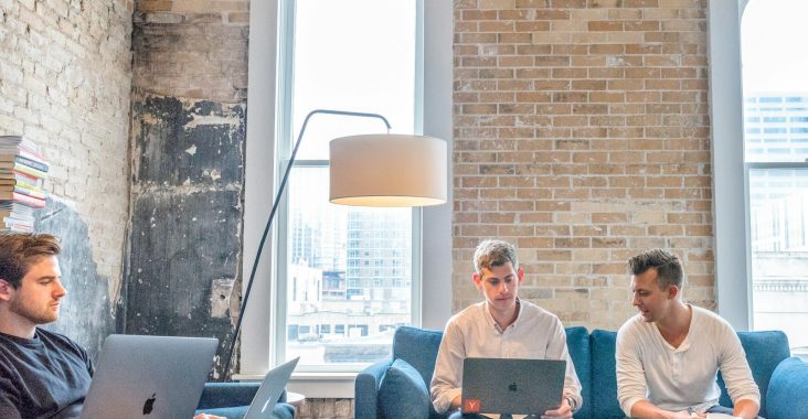 three men using MacBooks