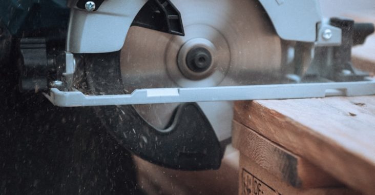 a person using a circular saw to cut a piece of wood